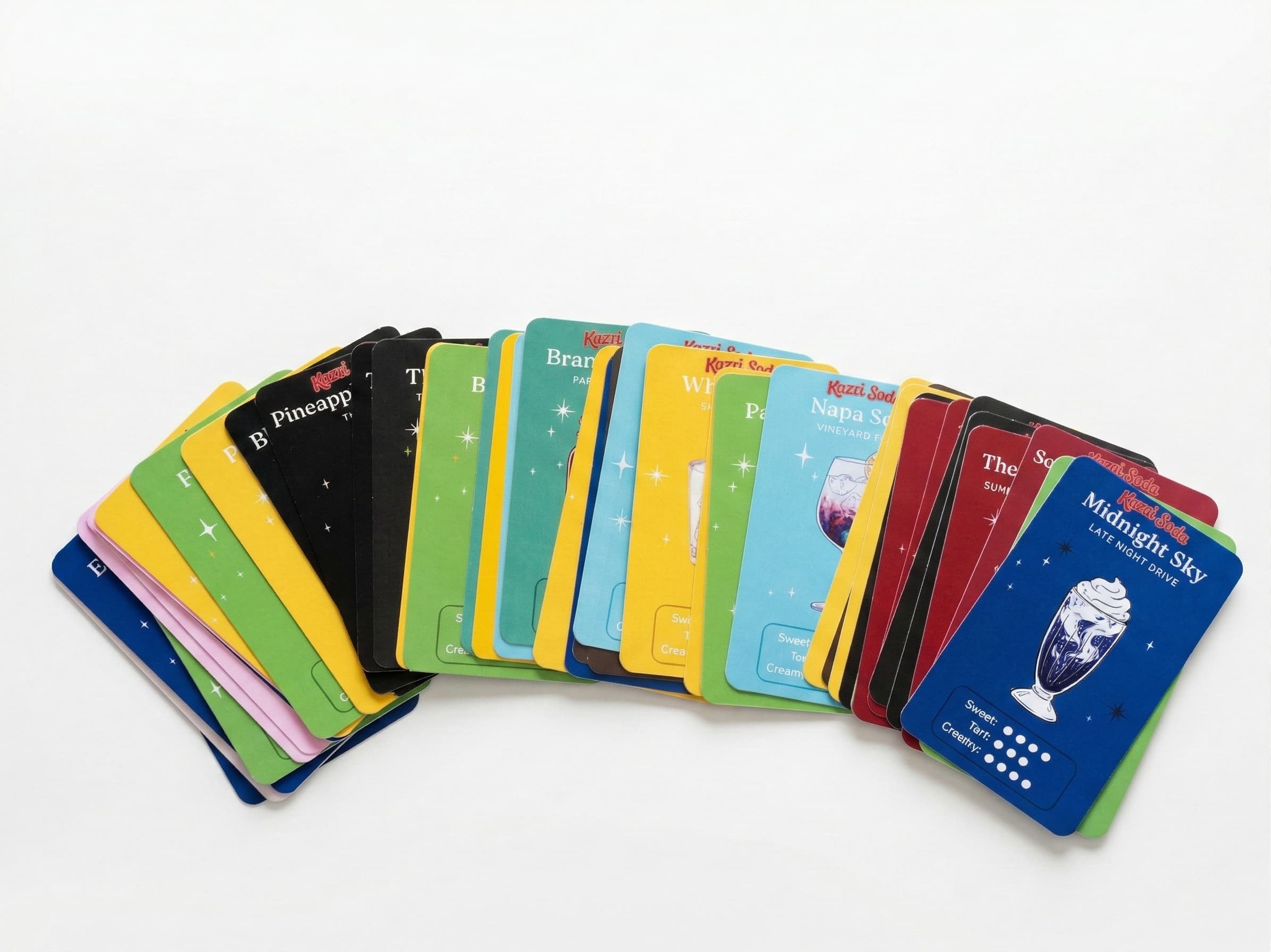 Kazzi Soda dirty soda recipe cards fanned out showing colorful drink recipes